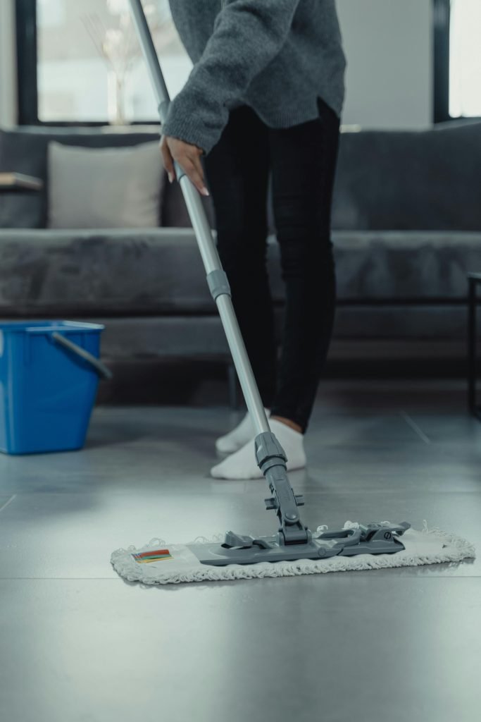 pexels photo 6196566 6196566 Close-up of person mopping a clean tile floor in a contemporary living room.